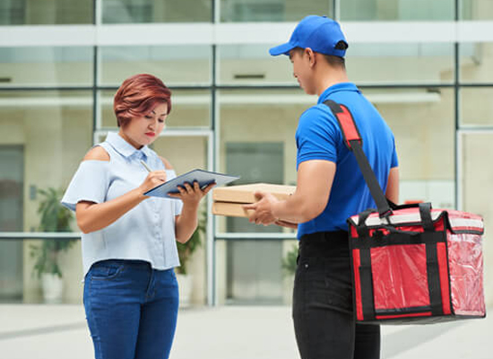 Courier collecting signature for package delivery